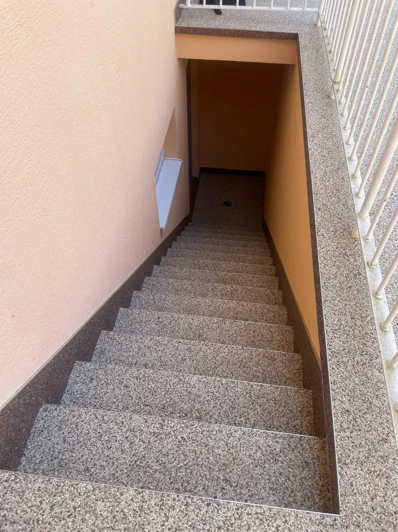 Innentreppe mit heller Körnung und dunkler Einfassung